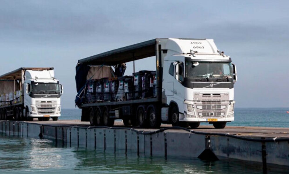 (Staff Sgt. Malcolm Cohens-Ashley/US Army Central via AP) Des camions chargés d'aide humanitaire provenant des Émirats arabes unis et de l'Agence américaine pour le développement international traversent la jetée du Trident avant d'entrer sur la plage de Gaza, le 17 mai 2024.