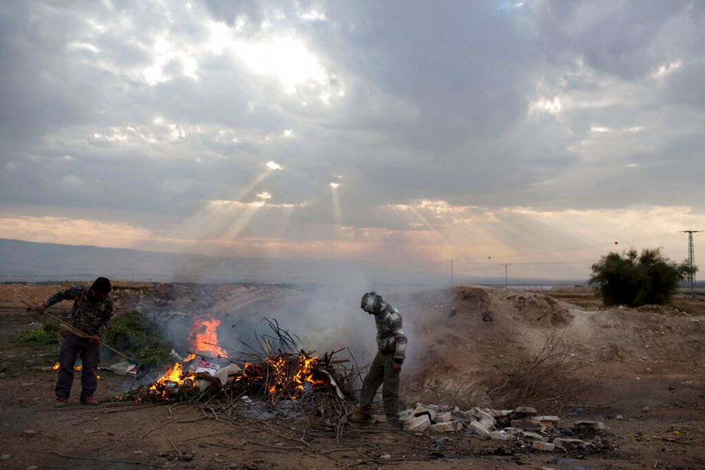 Palestinian farmers burn waste just outside the West Bank settlement of Petsael.