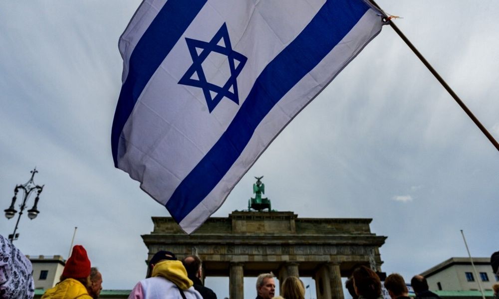 Un manifestant brandit un drapeau israélien lors d'un rassemblement de solidarité avec Israël devant la porte de Brandebourg à Berlin, en Allemagne, le 22 octobre 2023