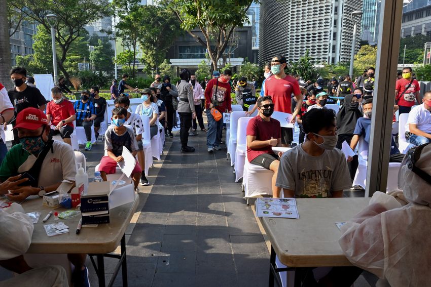 Les gens font la queue pour un test de dépistage rapide du coronavirus parrainé par la police nationale indonésienne à Jakarta le 21 juin 2020
