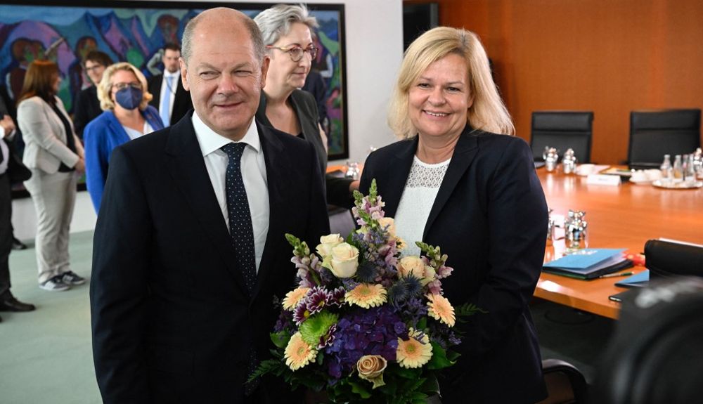 Le chancelier allemand Olaf Scholz remet un bouquet de fleurs comme cadeau d'anniversaire au ministre allemand de l'Intérieur Nancy Faeser