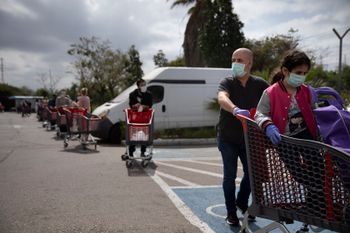Customers wear face masks as they line up to enter a supermarket keeping social distancing following the government's measures to help stop the spread of the coronavirus, in Tel Aviv, Israel, April 7, 2020