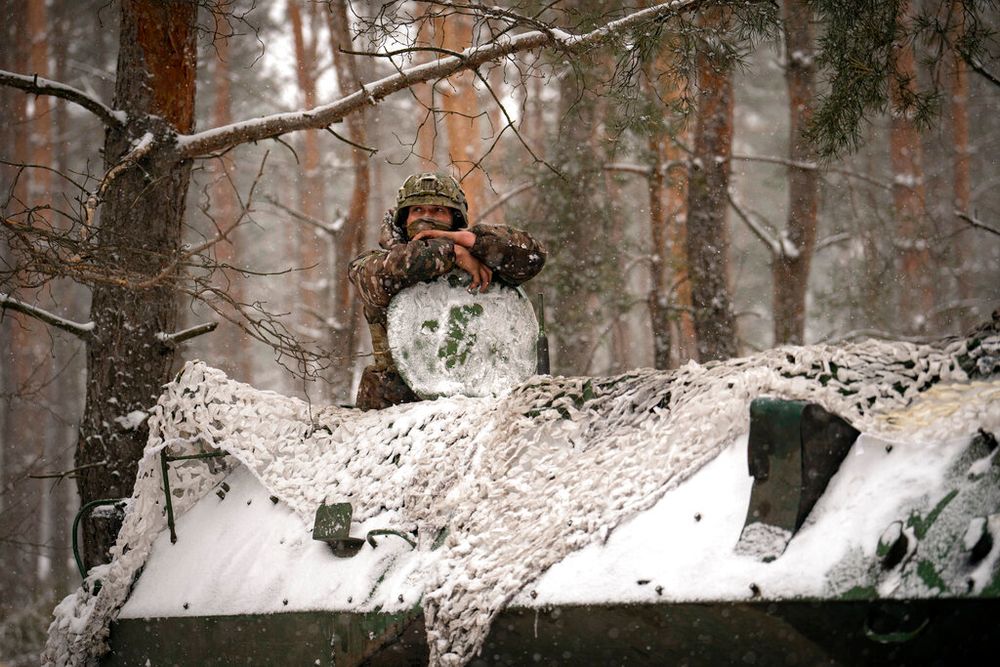 A Ukrainian serviceman peers from an armored transporter during a short stop outside Kupiansk, Ukraine.