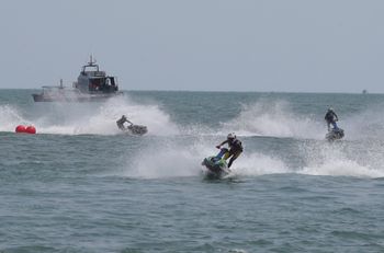 Jet ski competitors from Thailand, Philippines, and Malaysia, perform over the Sihanoukville coastal beach during the semi-final of the 32nd Southeast Asian Games in Sihanoukville, Cambodia.
