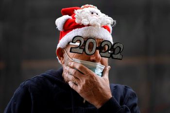 An Israeli vendor wears a pair of 2022 glasses to advertise a festive accessories store in Tel Aviv, Israel, December 31, 2021.