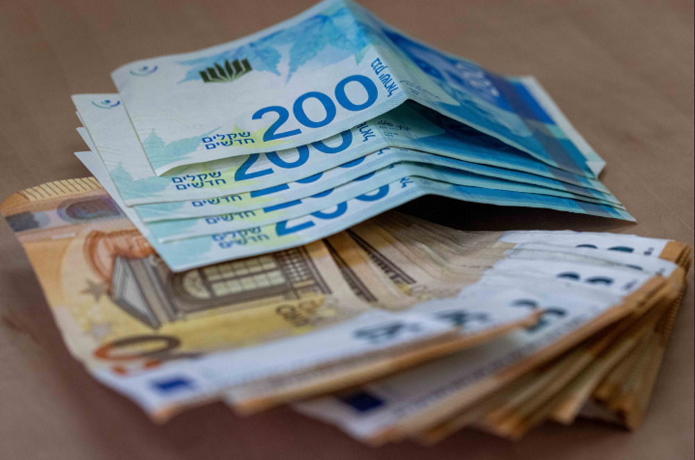Lot de billets de banque de 50 euros et de 200 billets de cent shekels sur une table à Jérusalem, le 17 novembre 2021.