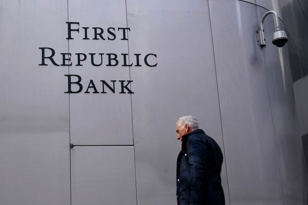 A pedestrian walks past a sign at a First Republic Bank in San Francisco, California, USA
