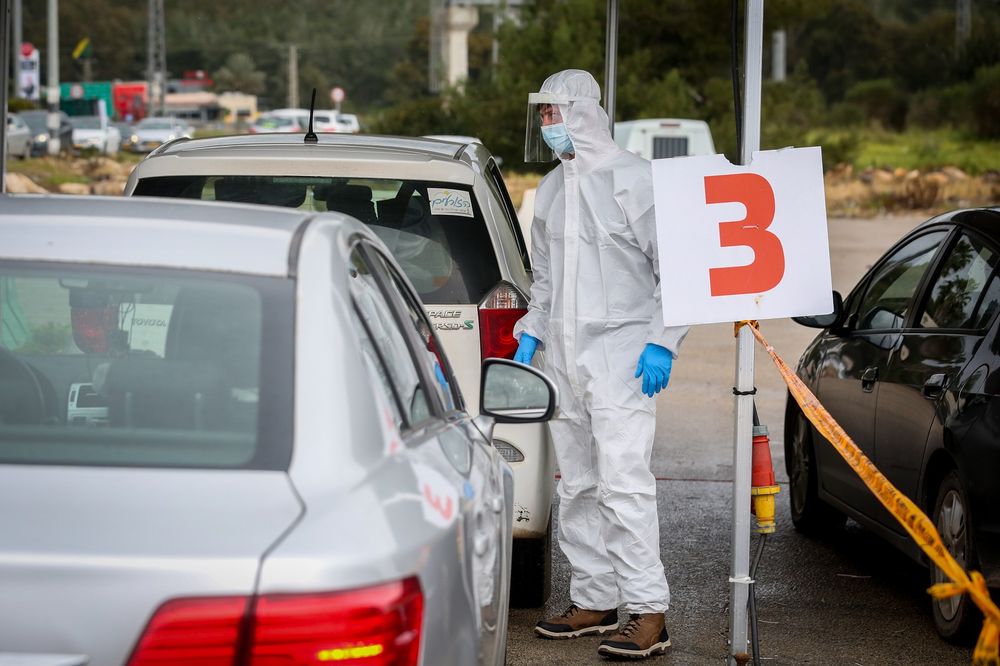 Health care workers take test samples of Israelis in a drive through complex to check if they have been infected with Covid-19, at the Golani Interchange, northern Israel, on March 4, 2021.