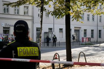 Police officers investigate and guard in front of the building complex of the Kahal Adass Jisroel community, which houses a synagogue, a kindergarten and a community center, in the center of Berlin, Germany, Wednesday, Oct. 18, 2023.