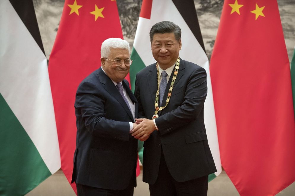 Palestinian President Mahmoud Abbas (L) shakes hands after presenting a medallion to Chinese President Xi Jinping during a signing ceremony at the Great Hall of the People in Beijing on July 18, 2017.