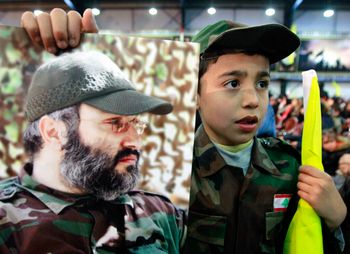 أحد أنصار حزب الله يحمل صورة القائد العسكري الراحل لحزب الله عماد مغنية، خلال حفل إحياء ذكرى وفاة قادة حزب الله، في الضاحية الجنوبية لبيروت، لبنان، السبت 16 فبراير 2013