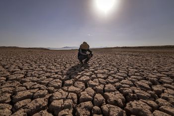 A child crouches over cracked earth at the Massira dam in Ouled Essi Masseoud village, Morocco, on August 8, 2022, amid the country's worst drought in at least four decades.