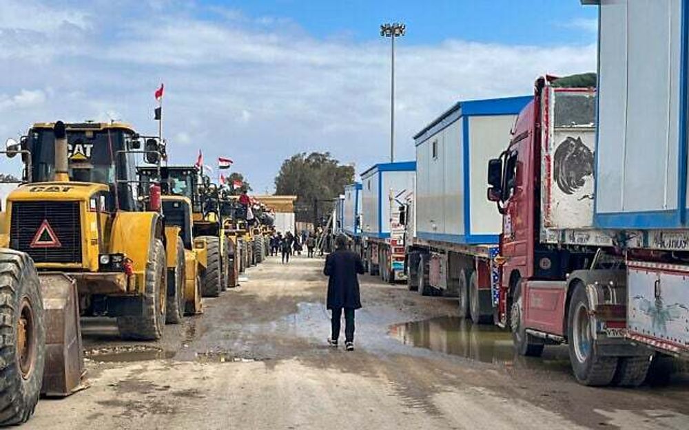 Des bulldozers et des camions transportant des maisons mobiles attendent d'entrer à Gaza au point de passage de Rafah entre l'Égypte et la bande de Gaza, le 13 février 2025