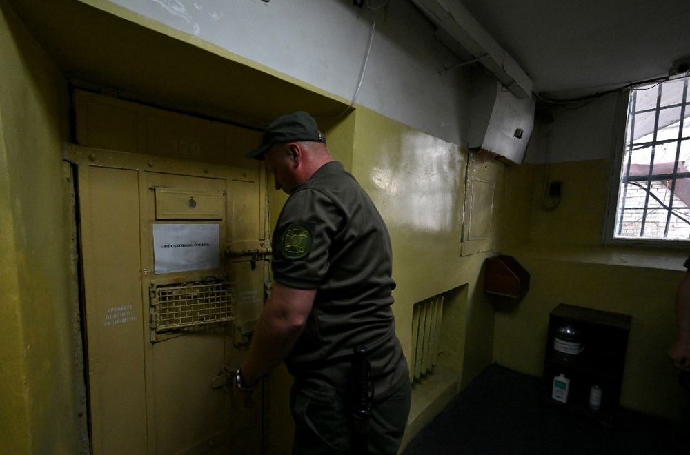 A jailer locks the door of a cell with signage indicating "Prisoners of War" at Lukyanivska Prison in Kyiv, Ukraine, amid the Russian invasion, on July 21, 2022.