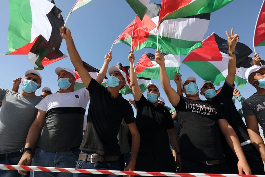 Des Palestiniens agitent des drapeaux lors d'un rassemblement à Jéricho pour protester contre le plan d'annexion par Israël de parties de la Cisjordanie et de la vallée du Jourdain, le 22 juin 2020