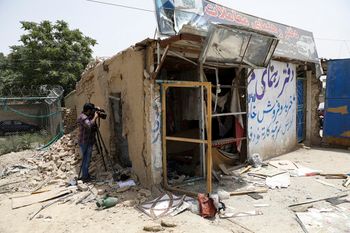 An Afghan journalist films the site of a bomb explosion in Kabul, Afghanistan, July 10, 2021.