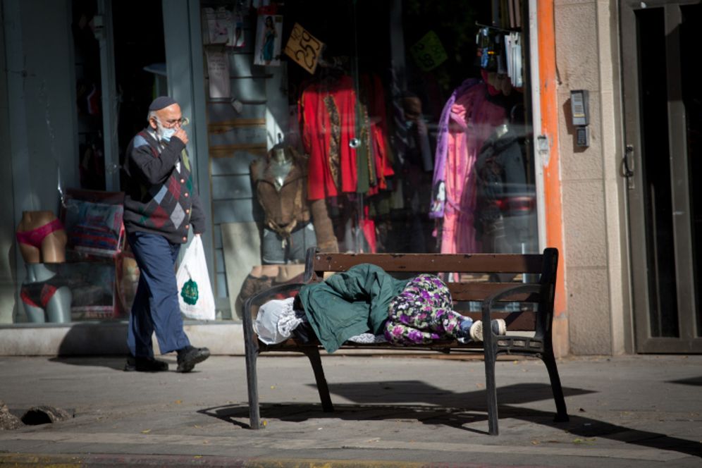 Une femme sans-abri dort sur un banc, rue Allenby à Tel Aviv, pendant le troisième confinement en Israël, 29 décembre 2020.
