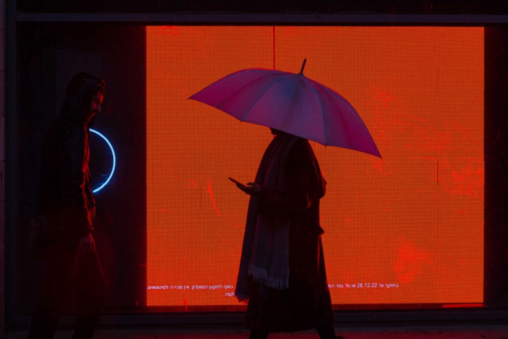 People take cover from the rain as they walk in Jerusalem.