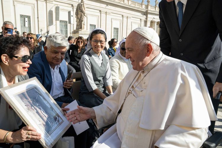 Pope Francis (R) receiving the framed 'Jesus from the Soil of the Holy Land' from Israeli professor Dina Porat in Vatican City.