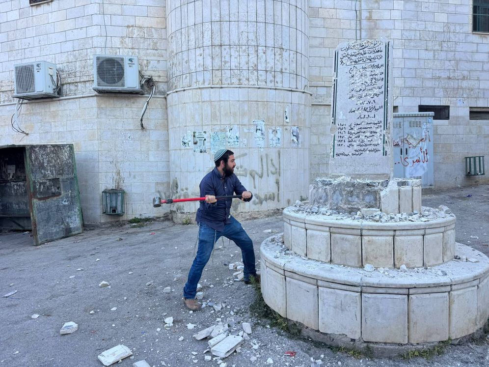 MK Zvi Sukkot demolishing a monument in a Palestinian Village