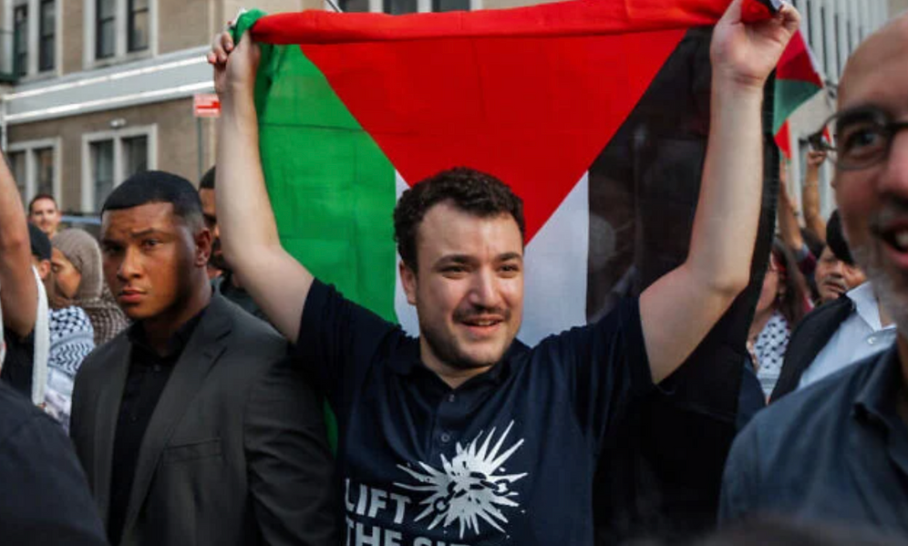  
Mahmoud Khalil, militant américain anti-israélien et pro-palestinien, brandit un drapeau palestinien lors d'un rassemblement célébrant son retour après avoir été détenu par les services d'immigration, le 22 juin 2025, à New York.