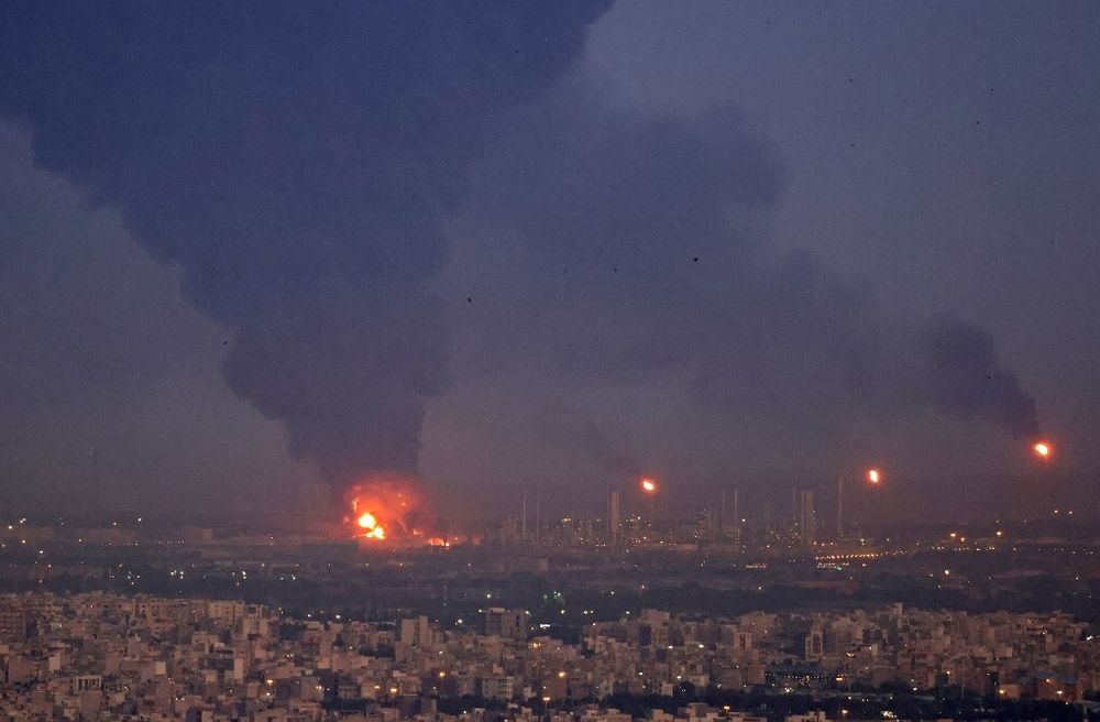 Illustration - An oil refinery in Iran on fire, with smoke billowing.