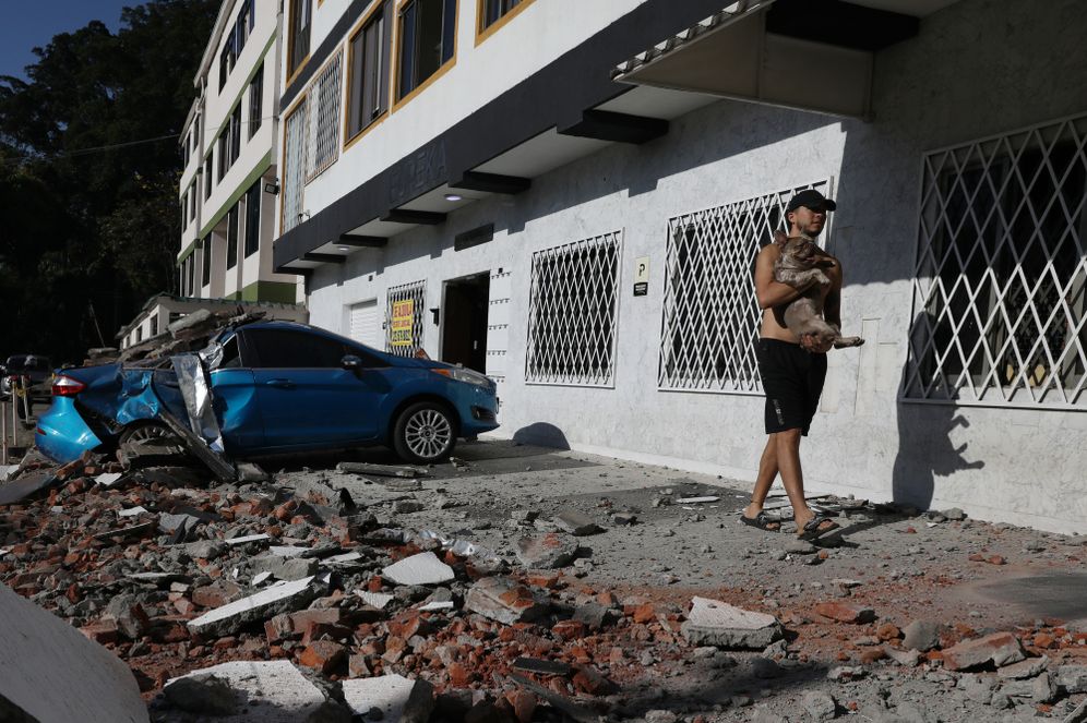 (AP Photo/Santiago Saldarriaga) A man carries his dog after an earthquake struck Cali, Colombia, Monday, Aug. 10, 2026