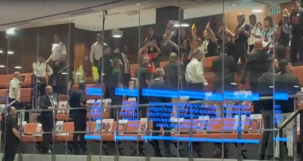 Families of hostages spread yellow paint on their hands and the panes of the mezzanine at the Knesset