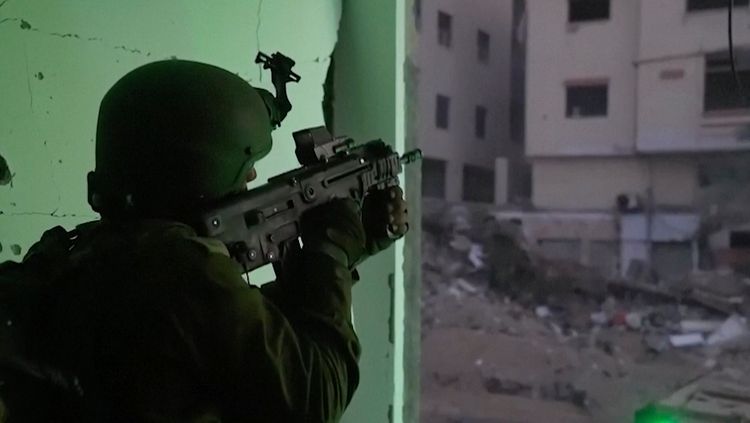 Sur cette image tirée d'une vidéo publiée par les Forces de défense israéliennes le 15 novembre 2023, un soldat israélien tient une arme dans la ville de Gaza.
