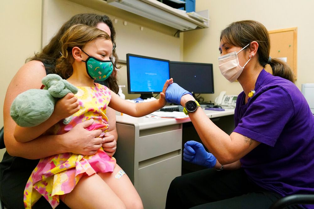 Nora Burlingame gives a fist bump to nurse Luann Majeed after getting a Pfizer Covid vaccine shot in Washington, the United States, on June 21, 2022.