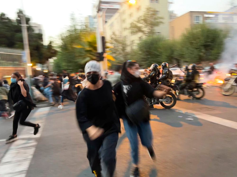 Des femmes fuient la police anti-émeute lors d'une manifestation pour protester contre la mort de Mahsa Amini, 22 ans lors de son arrestation par la police des mœurs la semaine dernière en Iran, lundi 19 septembre 2022