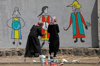 Yemeni women paint graffiti on a wall to mark International Women's Day, in Sanaa, Yemen.