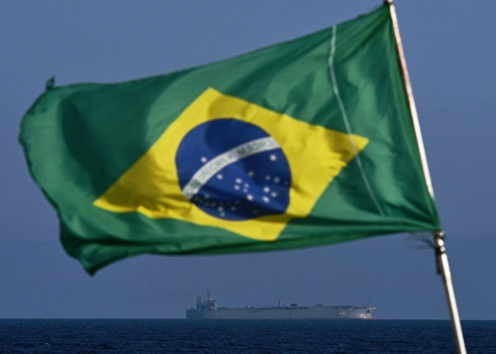 A Brazilian flag waves while the Iranian warship IRIS Makran sails on the coast of Rio de Janeiro, Brazi.