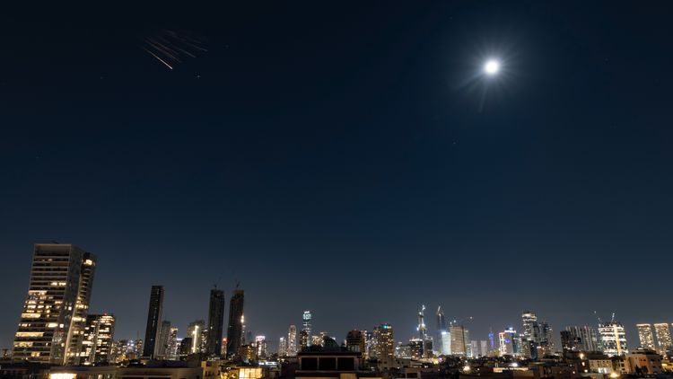 Anti-missile batteries fire interception missiles toward incoming ballistic missiles launched from Iran, as seen over Tel Aviv