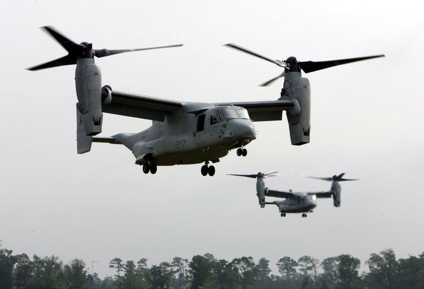 Two V-22 Ospreys, a tilt-rotor aircraft, hover over a treeline during a media day demonstration at Marine Corps Air Station New River in Jacksonville, N.C., Wednesday, July 13, 2005