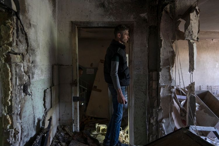 A man inspects his office damaged by a drone during a night attack, in Kyiv, Ukraine.