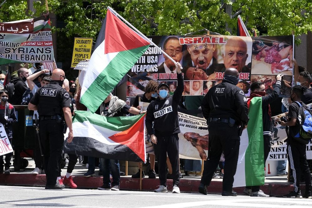 Police officers stand by during a protest against Israel and in support of Palestinians outside the Israeli Consulate in Los Angeles, California, on May 11, 2021.