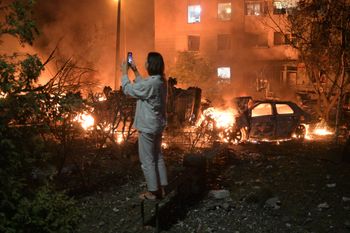 A woman takes photo of destructions following Russian missile attacks in Kyiv, Ukraine, Monday, July 6, 2026. 
