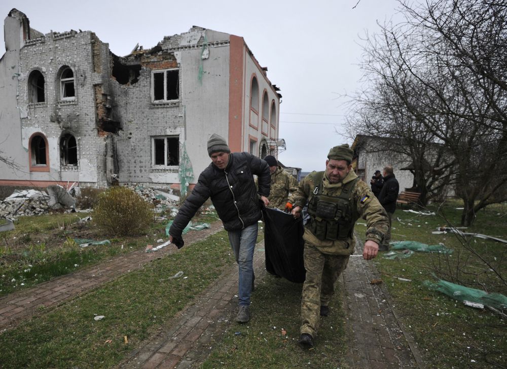 Rescuers carry a body in the village of Andriivka, Kyiv region, on April 10, 2022.