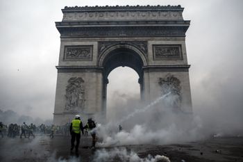 Demonstrators clash with riot police at the Arc de Triomphe during a protest of Yellow vests (Gilets jaunes) against rising oil prices and living costs, on December 1, 2018 in Paris.
