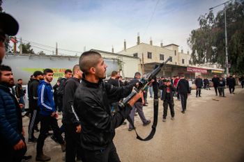 Palestinian gunmen hold their weapons after an Israeli military raid in Tulkarem, in the West Bank.