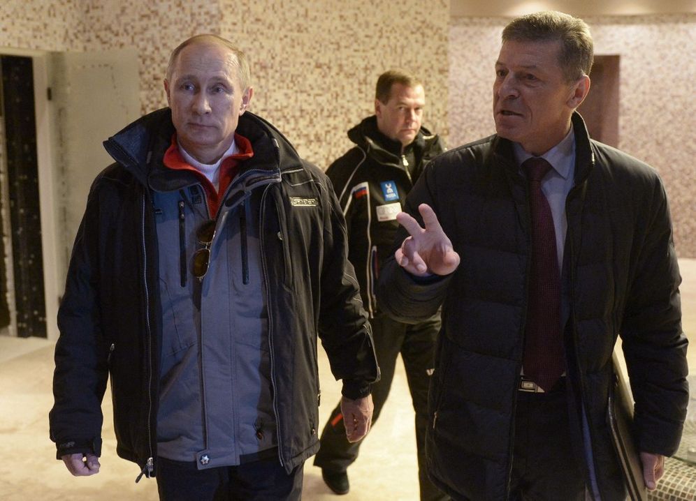 Russia's President Vladimir Putin (L) listens to then-Russian deputy prime minister Dmitry Kozak during his visit to the Krasnaya Polyana resort near the Black Sea city of Sochi, Russia, on January 3, 2014.