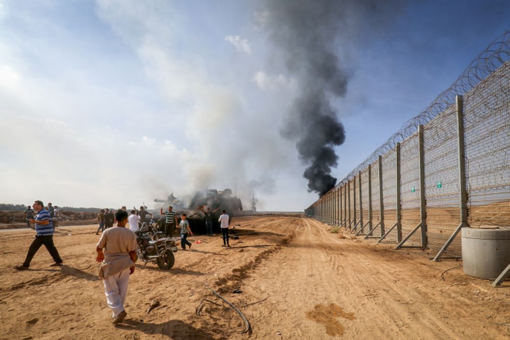 Palestinians take control of an Israeli tank after crossing the border fence with Israel from Khan Yunis, in the southern Gaza Strip, October 7, 2023.