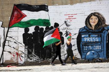 Palestinians walk past a mural for Al Jazeera journalist Shireen Abu Akleh in the West Bank city of Bethlehem, on May 16, 2022.