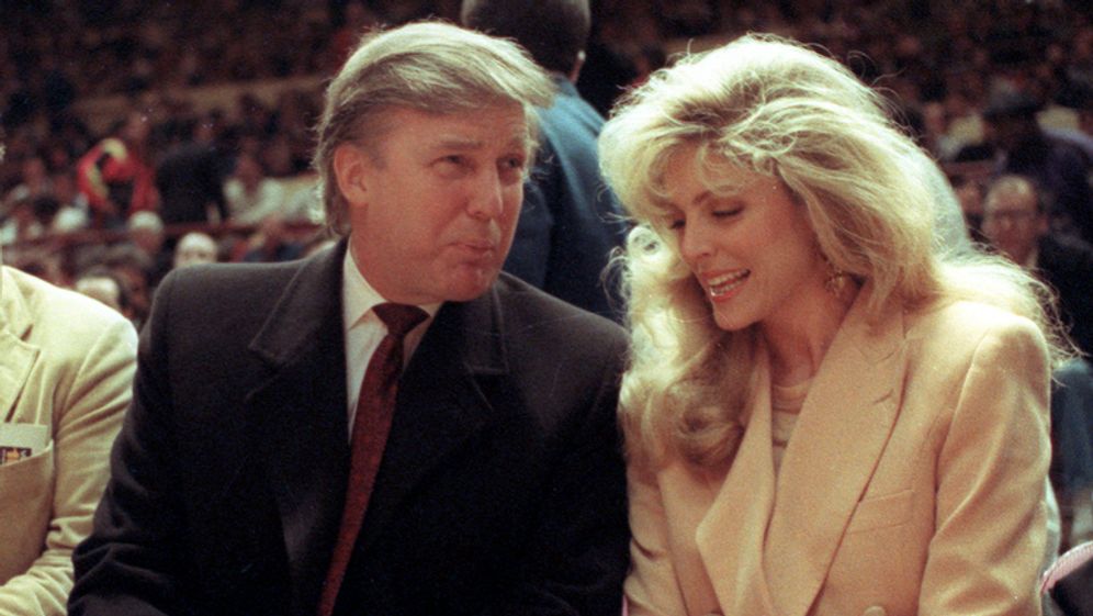 Donald Trump, center, and Marla Maples at courtside during an NBA basketball game between the Phoenix Suns and the New York Knicks at Madison Square Garden, in New York, Tuesday, March 6, 1991.