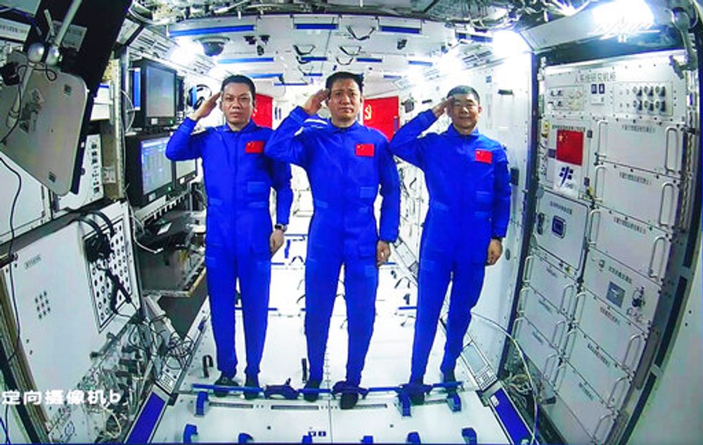 Astronautas chineses, a partir da esquerda; Tang Hongbo, Nie Haisheng e Liu Boming saúdam a bordo do módulo central da estação espacial chinesa Tianhe durante uma conversa por vídeo com o presidente chinês Xi Jinping, em 23 de junho de 2021.