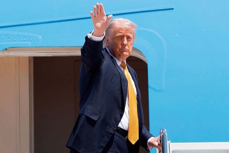 President Donald Trump waves from the stairs of Air Force One as he boards upon his arrival at Joint Base Andrews, Md., Tuesday, May 12, 2026, for a trip to China to meet President Xi Jinping. 