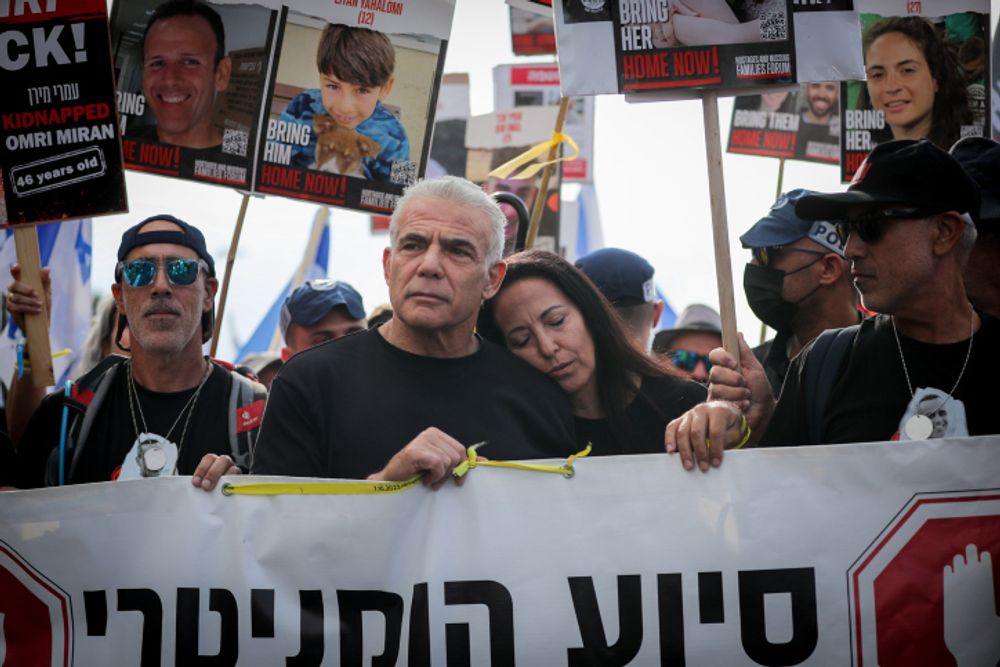 Yair Lapid e sua esposa Lihi marcham com as famílias de israelenses sequestrados por terroristas do Hamas em Gaza, em 18 de novembro.