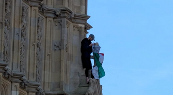 Man climbs Big Ben with a Palestinian flag.
