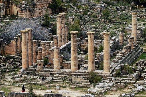 امرأة تمر عبر أنقاض معبد أبولو في مدينة قورينا شرق ليبيا القديمة ، في منطقة الجبل الأخضر ، في 10 فبراير 2022.